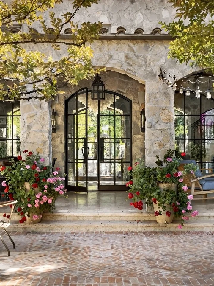 Stone archway and steel doors opening onto a brick courtyard in Hidden Hills